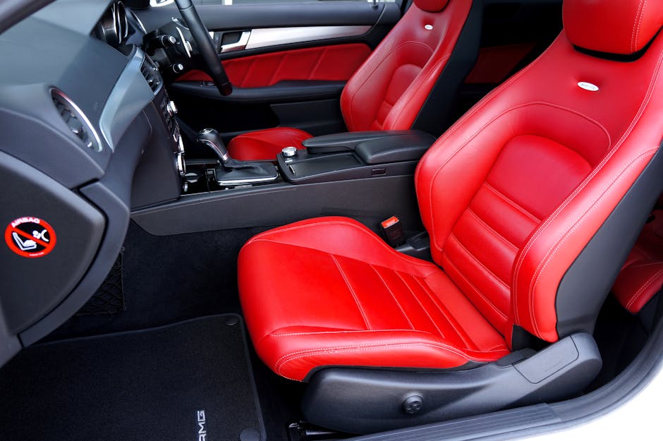 A professional cleaner, standing in a well-lit living room with white walls, holds two beige cushions in her hands, demonstrating domestic upholstery cleaning. The sofa, covered with a white slipcover, is situated against the wall and appears clean and tidy. In the background, decorative pillows, including a black and white patterned cushion and an orange cushion, are arranged on the sofa. The room features a wooden table visible in the foreground, and natural light fills the space, emphasizing the cleanliness and maintenance of the upholstery. The image reflects thorough surface cleaning and hygiene practices undertaken by Carpet Cleaning W10 in a residential setting, aligning with their specialist upholstery cleaning service in Notting Hill, W10.